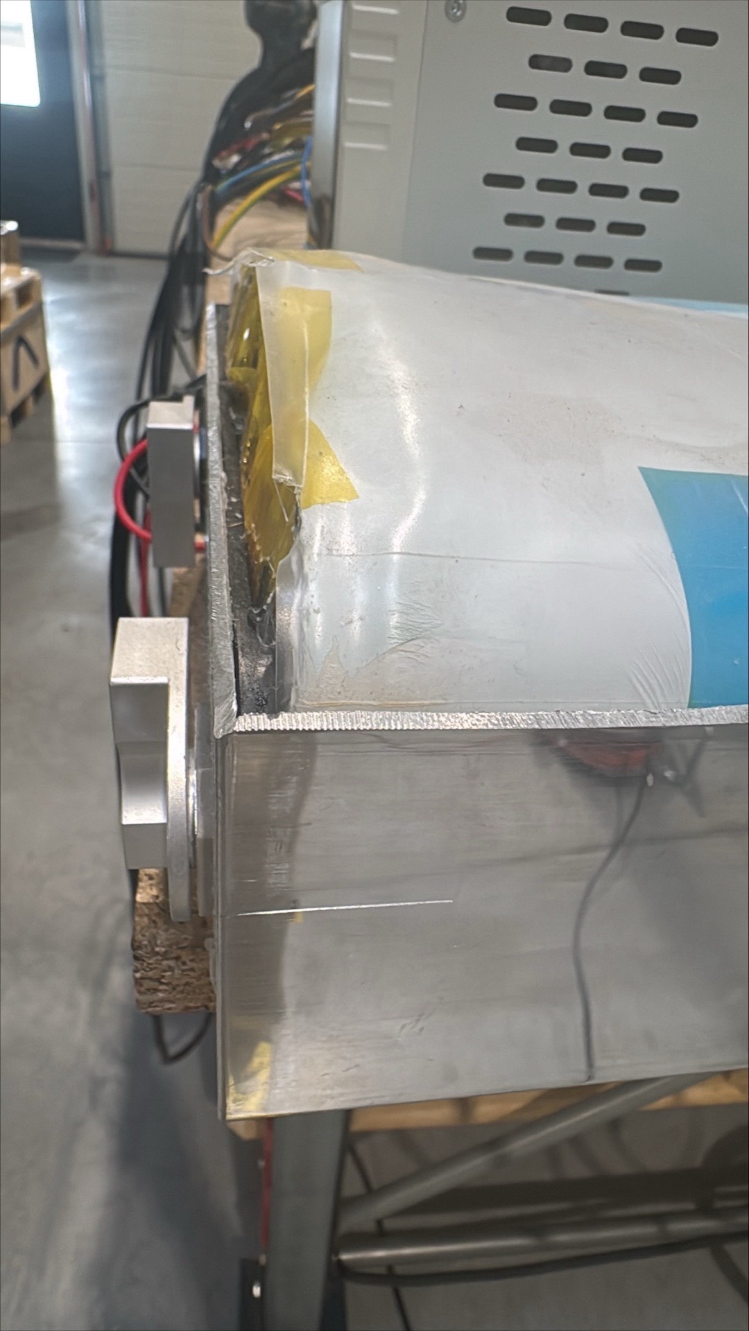 Close view of the edge of the same cell. The terminal plate is a separate piece of metal, with a visible void between it and the top of the electrode stack.