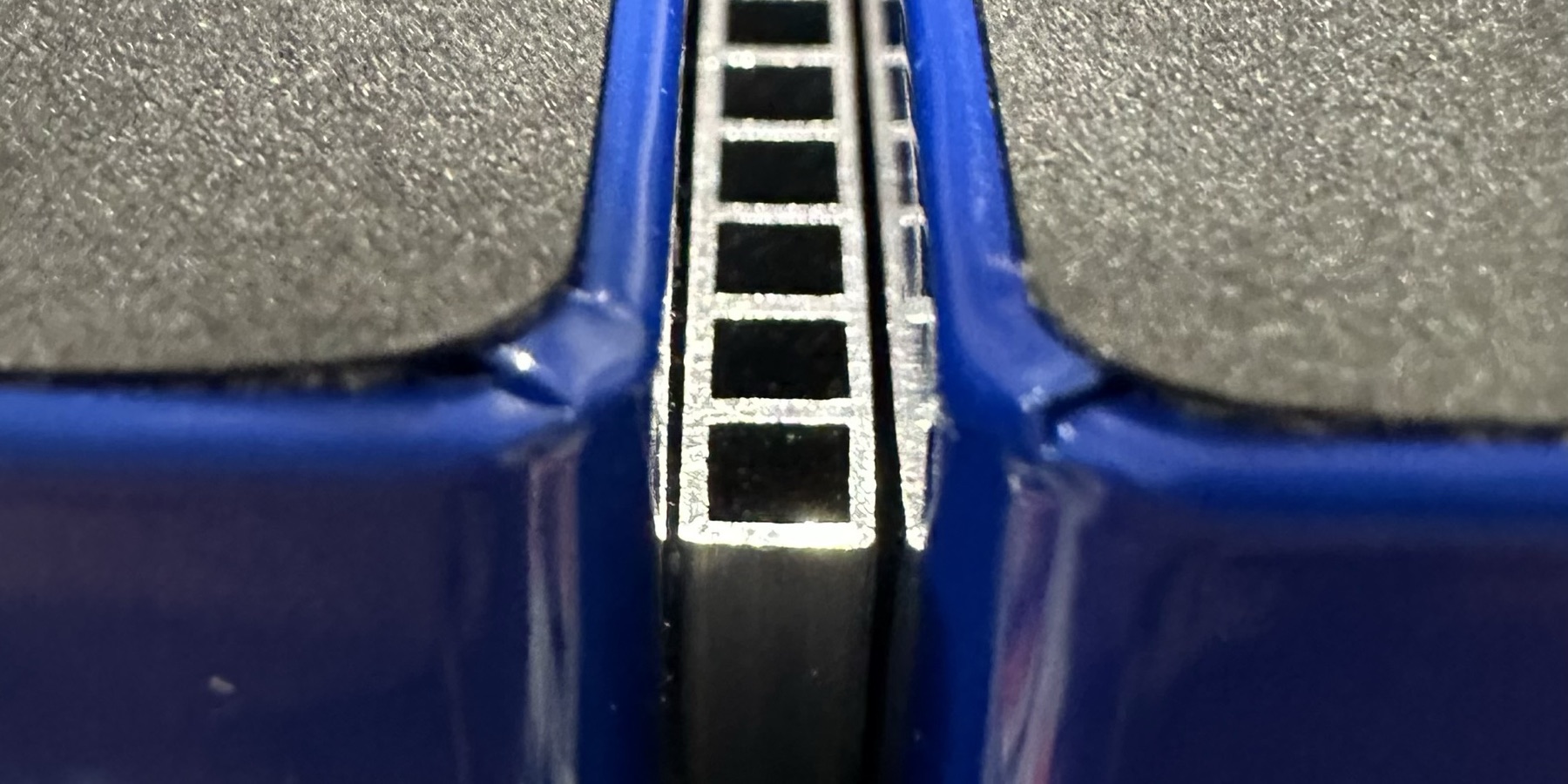 An aluminium inter-cell heat exchanger between two cells, its row of square channels running the length of the cell faces.